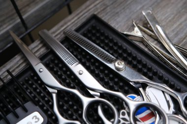 Eski ahşap arka plan ve lastik minder üzerinde klasik berber aletleri.