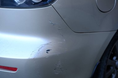 Gri metalik arabanın arka tamponu çizilmiş. Arabada hasarlı arka tampon yakın çekim görüntü. Bir çizik araba sigorta şirketi için Fotoğraf