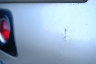 Gri metalik arabanın arka tamponu çizilmiş. Arabada hasarlı arka tampon yakın çekim görüntü. Bir çizik araba sigorta şirketi için Fotoğraf