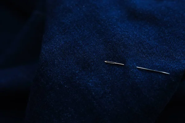 Kot pantolon arkaplan dokusunda dikiş ipliği ve iğne. Terzi el yapımı kot pantolon konsepti.