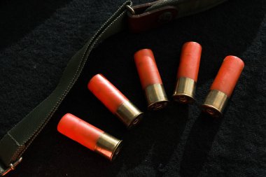 Siyah bir yüzeyde av tüfeği kovanları. 12 kalibrelik pürüzsüz silahlar için mühimmat. Cephanelik avlıyorum. Koyu arkaplan