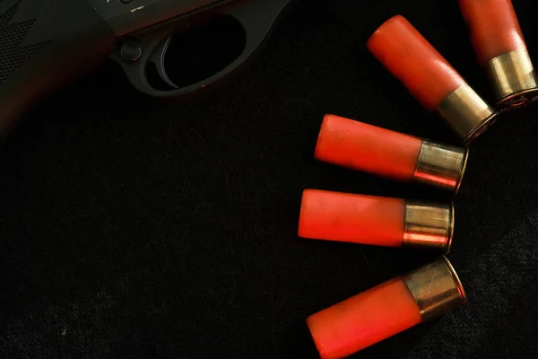 Trigger of a rifle on black background with red lightning with Shotgun shells on a black surface. Ammunition for 12 gauge smoothbore weapons. Hunting ammunition. Dark background