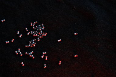 Koyu renk arka planda hava tabancası topakları ve aydınlatma için kırmızı ışık..