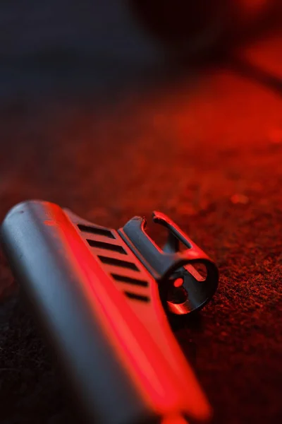 Rifle gun with air pellets for hunting on cloth dark background with red light illumination of the muzzle and pallet.