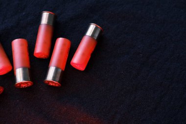 Siyah bir yüzeyde av tüfeği kovanları. 12 kalibrelik pürüzsüz silahlar için mühimmat. Cephanelik avlıyorum. Koyu arkaplan