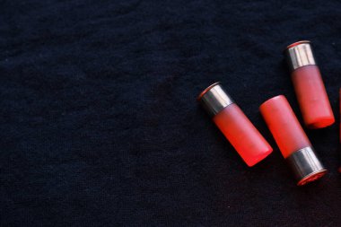 Siyah bir yüzeyde av tüfeği kovanları. 12 kalibrelik pürüzsüz silahlar için mühimmat. Cephanelik avlıyorum. Koyu arkaplan