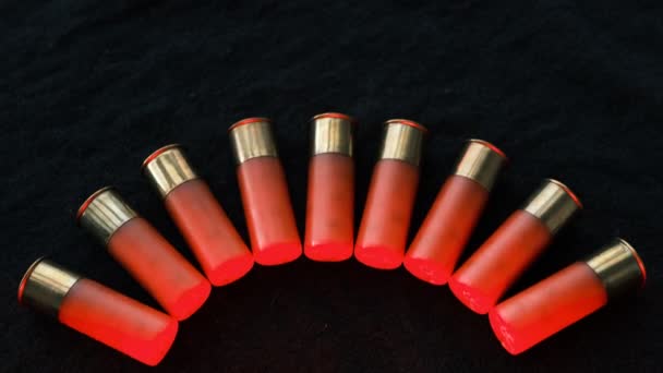 黒い表面に赤いショットガンの砲弾 12ゲージのスムーズな武器の弾薬 弾薬を狩る 暗い背景 — ストック動画
