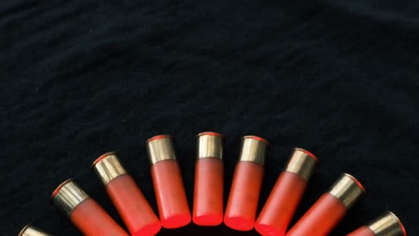 黒い表面に赤いショットガンの砲弾 12ゲージのスムーズな武器の弾薬 弾薬を狩る 暗い背景 — ストック動画