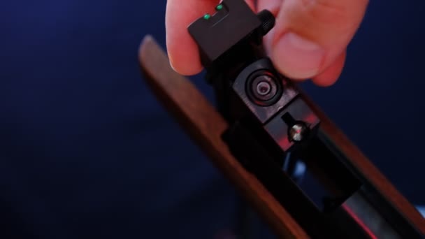 暗い背景に空気銃をロードする方法を示す男 空気銃で狩猟の概念 弾を挿入する手 — ストック動画