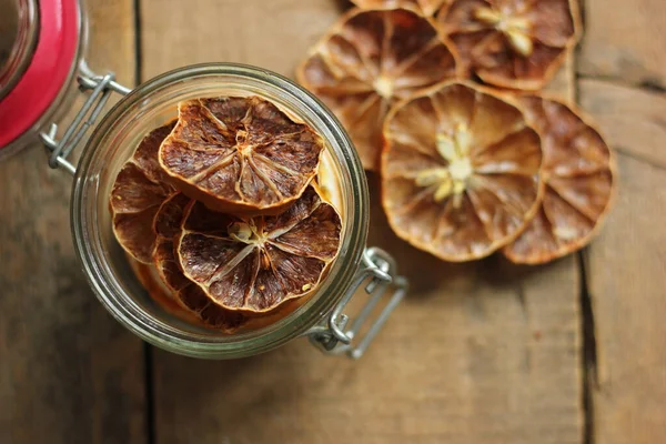 Cam kavanozda ev yapımı portakal dilimleri, karanlık bir masada portakal turşusu. Esmer bir arka plan, antika çanak çömlek, tarçın ve kurutulmuş portakal dilimleri. Kopyalama alanı, yakın plan