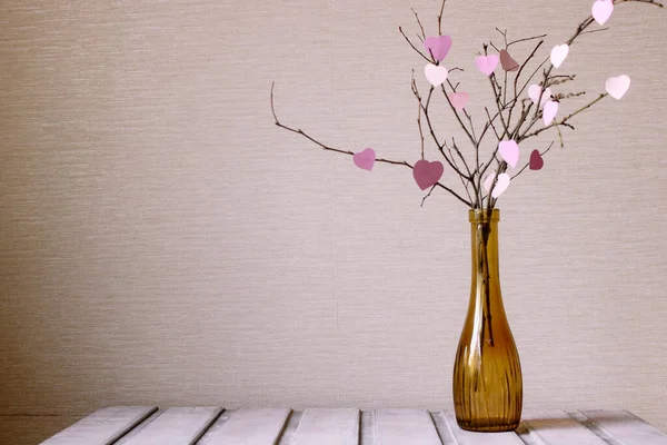 Sevgililer Günün kutlu olsun. Roze elementleri davetiye ya da poster için dalda asılı. Kağıt kalp şeklinde yaprakları olan neşeli bir ağaç.