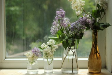 Pencere kenarındaki vazolarda bir demet leylak çiçeği. bahar zamanı kopyalama alanı .
