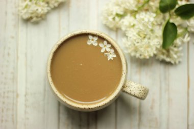 Beyaz arka planda izole edilmiş beyaz fincanda sütlü kahvenin üst görüntüsü. Kopyalama yolu.