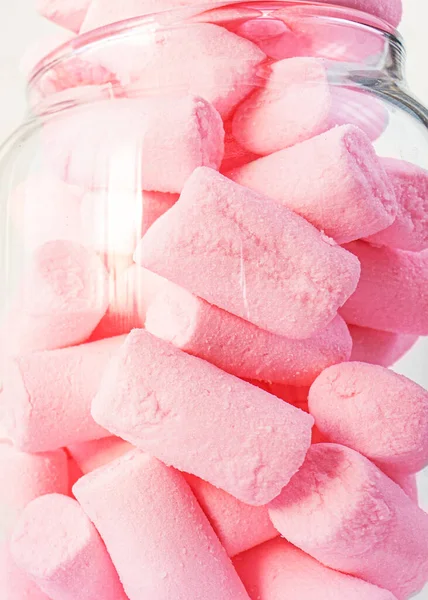 Beyaz arka planda pembe şekerlemelerle dolu eski cam şeker kavanozu. Kapatın. Seçici odaklanma. Şekerlemeli şekerler. Konsept pembe. Tatlı hayat.