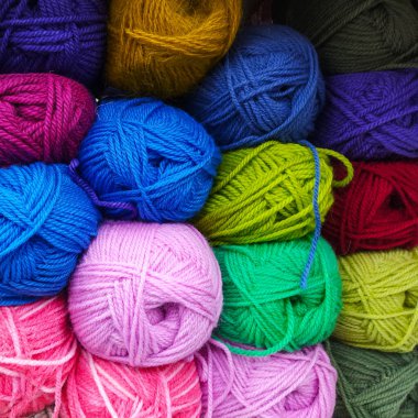 Renkli, çok renkli yün yumaklar. Renkli iplik yumaklarının arka planı. İğne işi. Örgü örüyorum. Hobiler ve boş vakitler. Çok renkli iplik topları. 