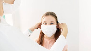 Gri arka planda şeker kutusuyla mavi renkte tıbbi şurup. Seçici odaklanma. İçinde ilaç şişesi olan bir çocuk için mavi sıvı ilaç bulunan ağız şırıngası masa arkasında duruyor. Çocukların dozaj formları. 
