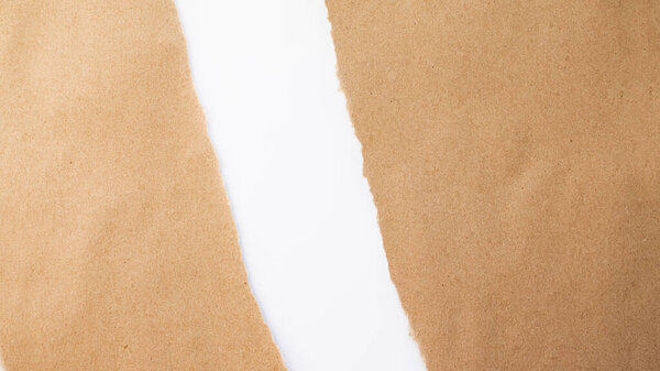 Диагонально разорванный край крафтовой бумаги на белом фоне. Бумажный фон. Порванная бумага. Текстура картона и крафтовой бумаги. Белый фон.