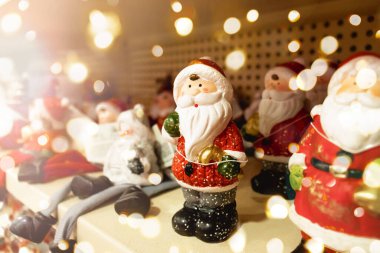 Seramik Noel Baba heykelcikleri bir mağaza rafında duruyor. Seçici odaklanma. Defocus Lightss. alışveriş merkezi Noel hediyesi konsepti. Noel ağacı için süslemeler. Noel indirimi. Noel kutlaması için alışveriş. Noel Fuarı.. 