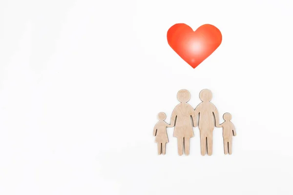 Beyaz arka planda bir ailenin tahta heykelciği. Seçici odaklanma. Ayrı bir nesne. Aile yaratma ve planlama konsepti. Dost canlısı bir ailenin ahşap silueti.