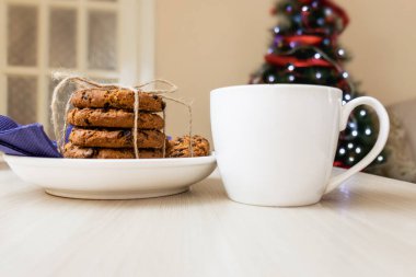 Noel Baba için kurabiyeler, bir yığın Noel Baba kurabiyesi ve beyaz bir kupa süt..
