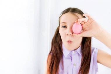 Paskalya yumurtasını gözlerinin yanında tutan çocuk şaşırır. Seçici odaklanma. Anlaşıldı. Mutlu Paskalyalar. Çocuklar ve Paskalya yumurtaları