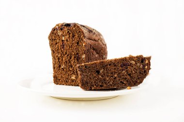 Beyaz bir tabakta kuru üzüm ve tohumla dilimlenmiş siyah çavdar ekmeği. Ekmek ve pişmiş yiyecekler.