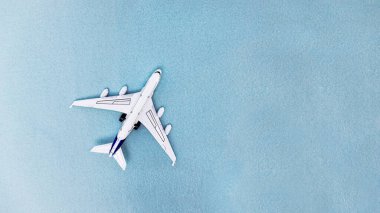 White plane and white envelope on a blue background top view. Selective focus.