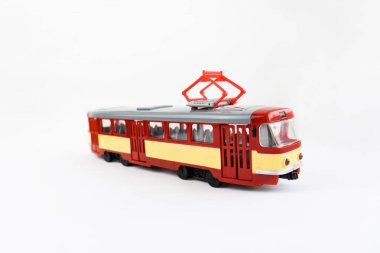Toy tram of red color on a white background, public transport. Object isolated on a white background. Selective focus