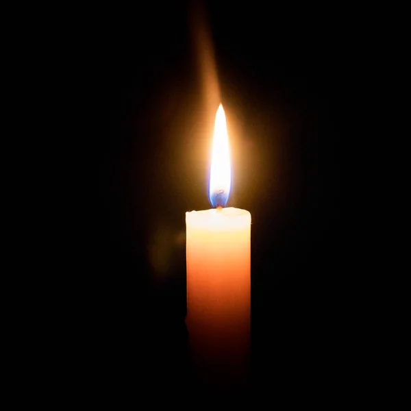 candles in the dark. the flame of a candle burning in the dark.