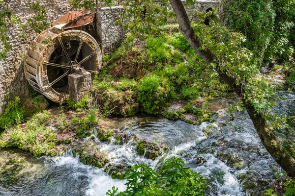 古い水車小屋の遺跡の近くにリヴァディアのギリシャの町の中心部に渓流が流れています — ストック写真