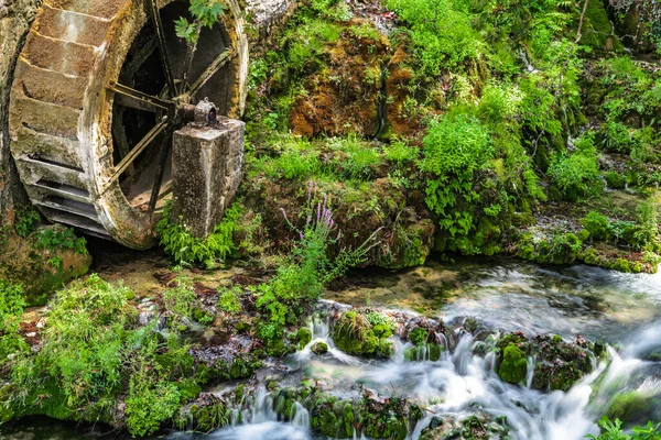 在希腊利瓦迪亚小镇的中心 一条山溪流淌着 靠近一座老旧的水磨坊的遗迹 水磨坊的轮子生锈了 — 图库照片