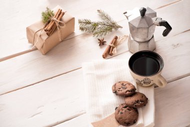 Noel arkaplanda el işi kağıt hediye kutusu, kahve demliği Noel Baba 'ya kurabiyeli bir fincan kahve ve klasik arka plan. Noel gelenekleri kavramını kabul et. Eko Noel. Tarçın çubukları, köknar dalları, sicim, anason....