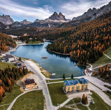 Misurina, Auronzo, İtalya - Bir sonbahar sabahı Tre Cime di Lavaredo tepeleri (Üç Merlon), sonbahar yaprakları ve mavi sabah gökyüzü ve bulutları ile İtalyan Dolomitlerindeki Misurina Gölü 'nün havadan görünüşü