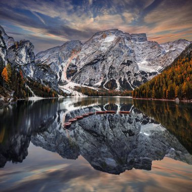 Braies Gölü, İtalya - İtalyan Dolomitleri 'ndeki Braies Gölü' nde (Iago di Braies) muhteşem sonbahar gündoğumu ahşap botlar ve gölde yansıyan Seekofel Dağı ile
