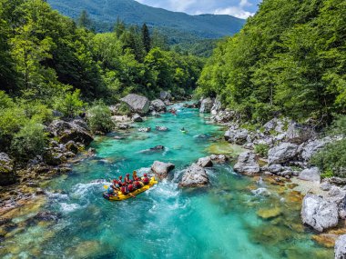 Soca Vadisi, Slovenya - Parlak güneşli bir yaz gününde yeşil yapraklarla nehirden geçen rafting botlarıyla zümrüt Alp Nehri 'nin havadan görünüşü. Slovenya 'da rafting