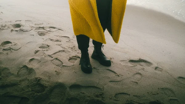 Plajda siyah botlarla yürüyorum.