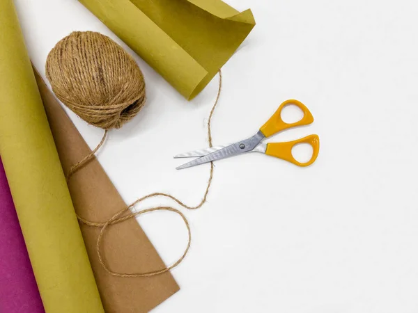 Composition of twine, kraft paper and scissors, top view. — Stock Photo, Image