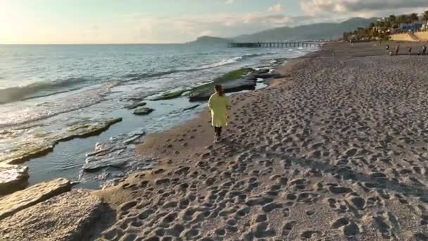 Sarı Paltolu Bir Kız Sahilde Yürüyor — Stok video
