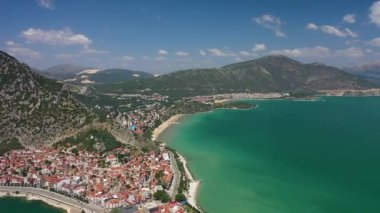 Büyük bir gölün kıyısında bir şehir.