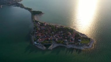 Büyük bir gölün kıyısında bir şehir.