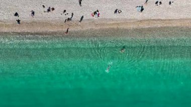 Mavi deniz ve liman kenti arka planıyla Alanya plajı dağ manzaralı.