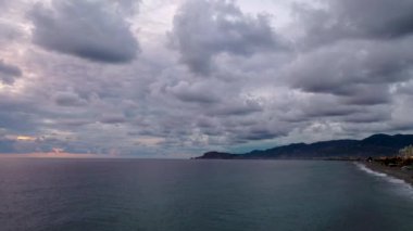 Deniz üzerinde bulutlu gün batımı