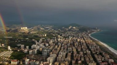 Gökkuşağı denizde ve şehrin üzerinde