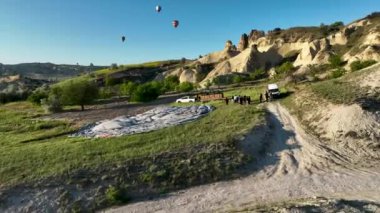 hot air balloons fly over the mountainous landscape of Cappadocia, Turkey. Aerial view