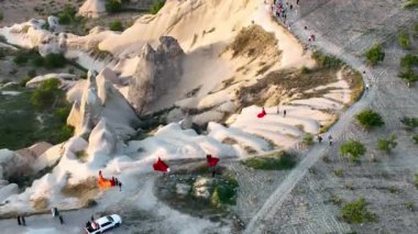hot air balloons fly over the mountainous landscape of Cappadocia, Turkey. Aerial view