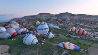 hot air balloons fly over the mountainous landscape of Cappadocia, Turkey. Aerial view