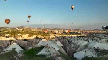 hot air balloons fly over the mountainous landscape of Cappadocia, Turkey. Aerial view