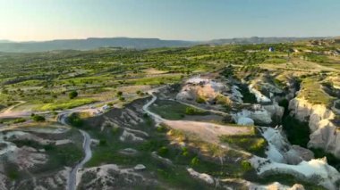hot air balloons fly over the mountainous landscape of Cappadocia, Turkey. Aerial view