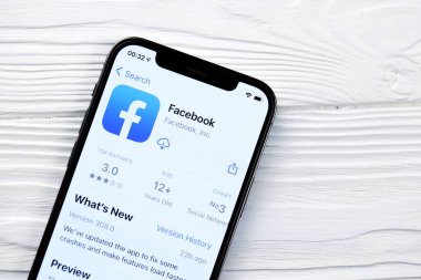 KHARKOV, UKRAINE - 5 Mart 2021: Facebook simgesi ve uygulaması iPhone 12 'den beyaz ahşap masadaki profesyonel ekranda