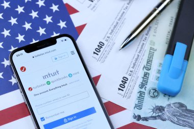 KHARKOV, UKRAINE - 5 Mart 2021: Turbotax sezgi web sitesi iPhone 12 profesyonel ekranda 1040 ve w-2 ABD bayrağında kağıt vergi formları